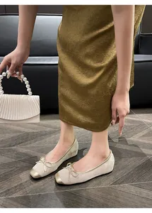 Detail of retro French-style ballet flats with bow and golden toe cap