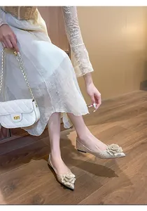 Detailed shot of golden glitter flat wedding shoes with elegant pointed toe and flower decoration