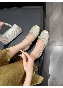 Detailed close-up view of French retro beige and gold leather ballet flats with bow.