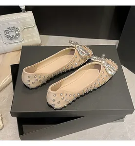 Detailed view of elegant rhinestone flat shoes with a sparkling bow detail.