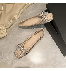 Detail of champagne flat shoes with sparkling rhinestone bow and crystal embellishments
