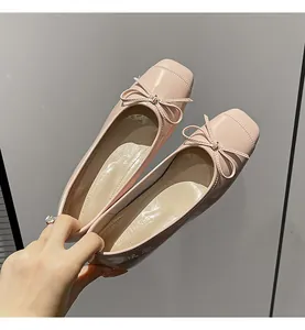 Close-up of pink patent leather ballet flats with dainty bow and square toe design