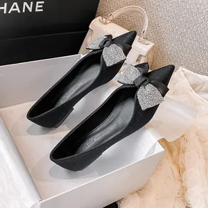 Elegante schwarze Ballerinas mit spitzer Zehenpartie und Strassschleife im Look.