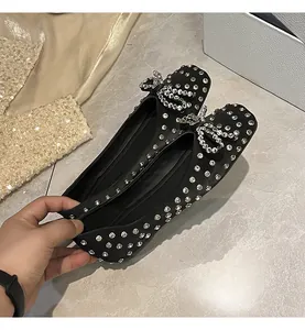 Detailed view of black rhinestone flat shoes with double crystal bow design