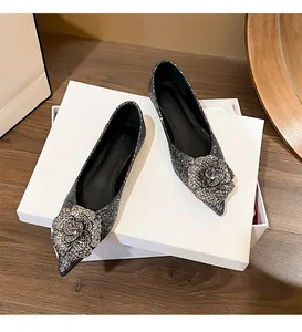 Detailed view of silver glitter pointed flats with a large glitter rose decoration.