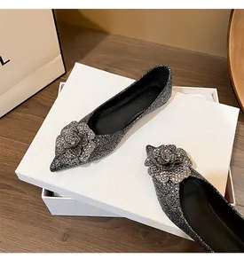 Silver glitter pointed-toe flats with sparkling rose decoration on white shoebox