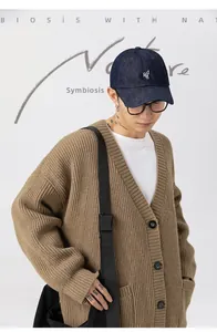 Dettaglio ravvicinato di un cardigan in maglia pesante kaki con motivo a nido d'ape