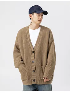 Primo piano di un cardigan pesante a maglia a coste color cammello con bottoni sul davanti.
