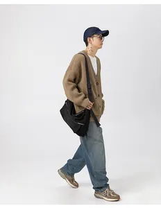 Look completo di un cardigan marrone in maglia grossa con jeans larghi e borsa.
