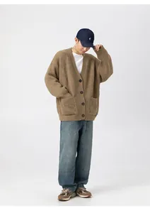 Dettaglio di un cardigan in maglia grossa pesante color kaki per uno stile minimalista