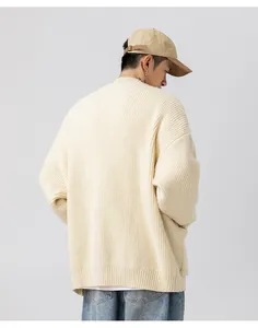 Vista posteriore del cardigan minimalista in maglia grossa bianco panna con trama spessa.
