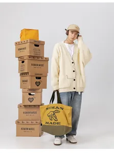 Dettaglio del cardigan in maglia pesante bianco crema con finitura testurizzata e bottoni