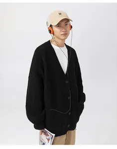 Vista dettagliata di un cardigan nero in maglia grossa oversize indossato da un modello