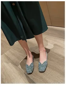 Detailed view of women's sparkling blue rhinestone square toe flat shoes on model