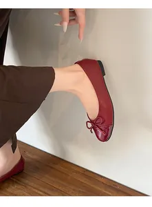 Close-up of French style red ballet flats with bow knot and glossy round toe.