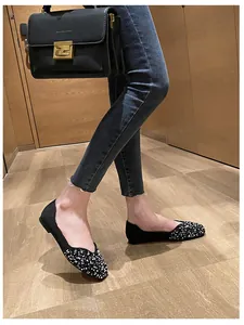 Elegant black square-toe flats with rhinestone detail shown in a lifestyle indoor setting