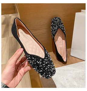 Detailed view of elegant black square toe flat shoes with pearl embellishments