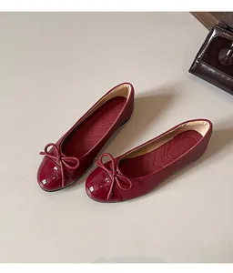 Detail view of burgundy French style ballet flats with elegant bow and round toe.