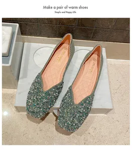 Detailed view of green square-toe flats with elegant pearl and bead embellishments.