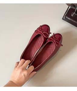 Detail view of elegant burgundy French-style ballet flats with a bow and soft sole.