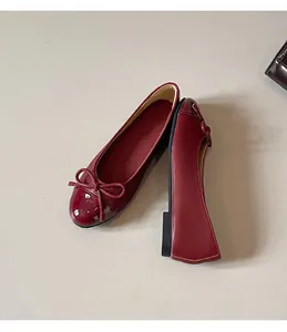 Detail view of red French ballet flats featuring elegant bow and patent leather toe