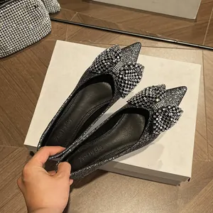 Elegant silver glitter pointed-toe flats featuring a large rhinestone bow detail
