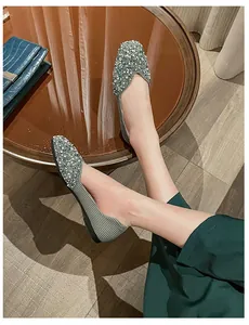 Close-up shot of elegant square-toe flat shoes featuring sparkling rhinestone details.