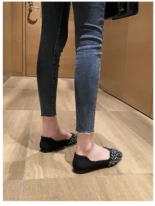 Detailed side view of black square-toe ballet flats with white polka dot accents