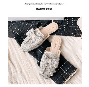 Detailansicht weißer Glitzer-Mule-Hausschuhe mit einem eleganten Schleifen-Design