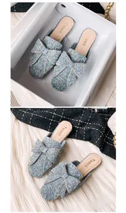 Detaillierte Ansicht funkelnder hellblauer Pailletten-Mules mit großen Schleifen