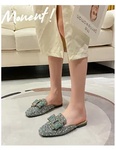 Detailed close-up view of sparkling silver rhinestone flat mules with decorative buckle