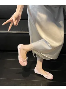 Detail shot of pink satin Tabi ballet flats with elegant bow and split-toe design.