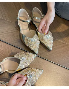 Detailed view of champagne gold pointed-toe pumps with ornate crystal beadwork embellishment