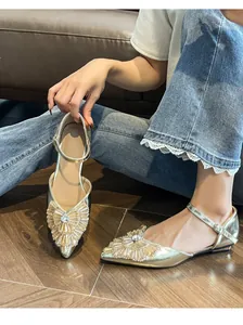 Elegant gold pointed-toe flat sandals featuring sparkling rhinestone details and ankle strap