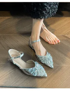 Close-up shot of silver pointed-toe flats featuring intricate sparkling rhinestone embellishments