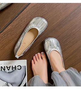 Vista dettagliata delle ballerine metallizzate argento stile Tabi su legno