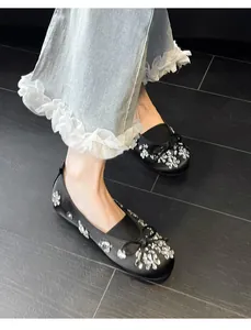Vue détaillée de ballerines noires avec d'élégantes fleurs en strass et un nœud
