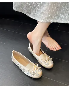 Détails des ballerines en satin champagne avec nœud orné de strass et motifs floraux