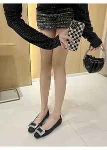 Elegante schwarze Seidensatin-Flats mit funkelnder Strassschnalle an einem Modell