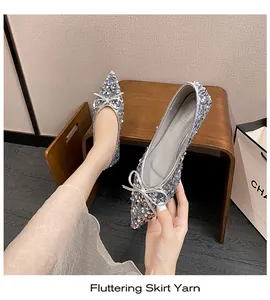 Nahaufnahme von silbernen Pailletten-Ballerinas mit spitzer Kappe und Schleife