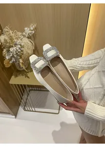 Detailansicht eleganter Satin-Ballerinas in Creme mit glitzernder quadratischer Strassschnalle.
