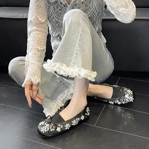 Ballerines noires élégantes ornées de fleurs en strass et d'un nœud délicat au pied.