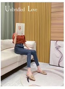 Model wearing champagne sparkling rhinestone bow mules in a stylish lifestyle setting