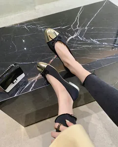 Primer plano de bailarinas bicolor elegantes con puntera dorada y lazo en la modelo