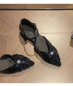 Elegant black pointed-toe flats with rhinestone buckle and beaded embellishment