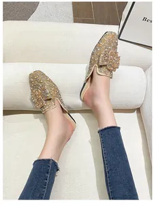 Detailed view of sparkling rhinestone-encrusted flat mule shoes with pearl accents