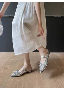 Detailansicht silberner flacher Schuhe mit glitzernden Strasssteinen und Perlenverzierung