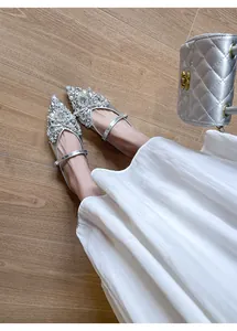 Elegante silberne spitze Ballerinas mit Strass und Perlen, auf den Füßen mit Kleid