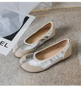 Nahaufnahme der silbernen Metallic- und beigen Wildledertexturen der Tabi-Ballerinas.