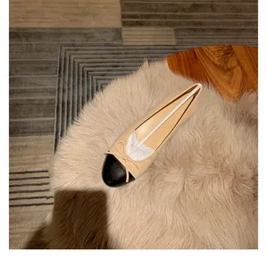Vista superior de elegantes bailarinas bicolor en beige y negro con lazo